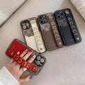 Gucci-inspired monogram phone case with studded hand strap